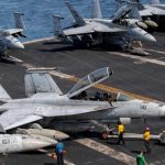 US sailors taxiing an F/A-18F Super Hornet, attached to Strike Fighter Squadron (VFA) 41, on the flight deck aboard Nimitz-class aircraft carrier USS Abraham Lincoln (CVN 72), in support of Operation Epic Fury, on March 17, 2026. (AFP)