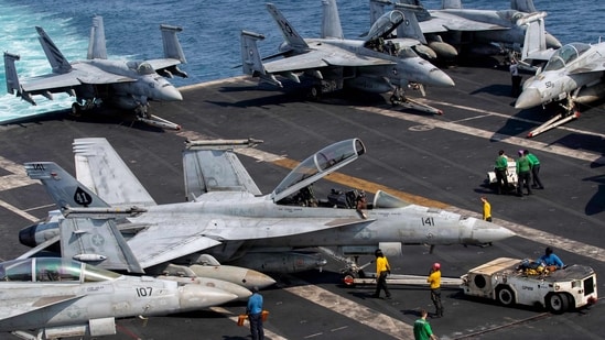US sailors taxiing an F/A-18F Super Hornet, attached to Strike Fighter Squadron (VFA) 41, on the flight deck aboard Nimitz-class aircraft carrier USS Abraham Lincoln (CVN 72), in support of Operation Epic Fury, on March 17, 2026. (AFP)