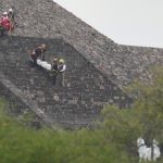 Forensic workers carry the body of a victim down a pyramid after authorities said a gunman opened fire, in Teotihuacan, Mexico. (AP)