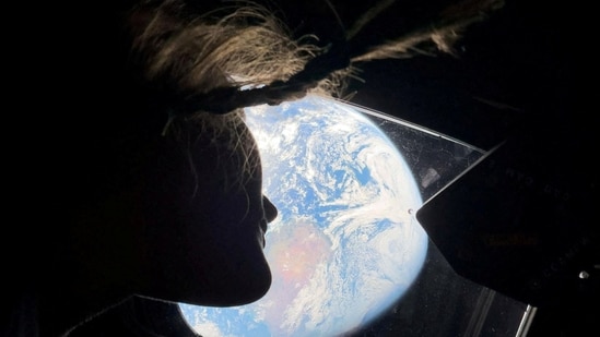NASA astronaut and Artemis II mission specialist Christina Koch peers out of one of the Orion spacecraft’s main cabin windows, looking back at Earth, as the crew travels towards the Moon, April 2, 2026. (via REUTERS)