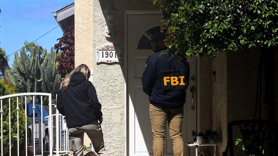 An FBI member stands outside a building next to the house associated with Cole Tomas Allen, the suspect in the shooting incident in Washington at the annual White House Correspondents’ Association dinner, in Torrance, California, U.S. (REUTERS)